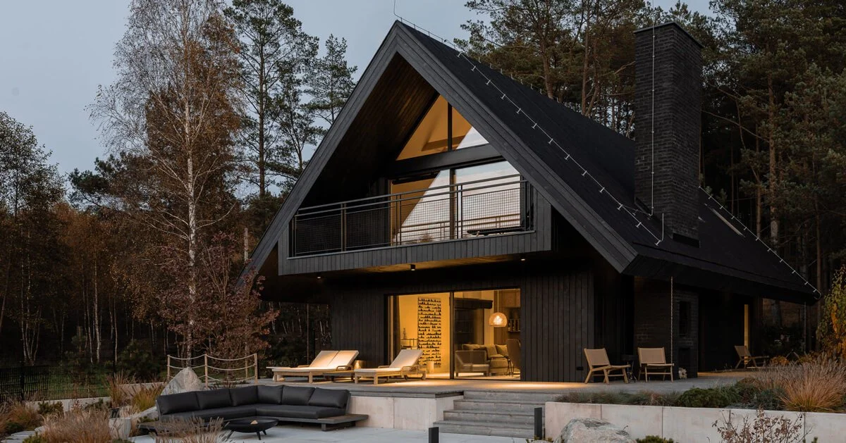 A&A House in Poland reinterprets barn form with dark timber among pines